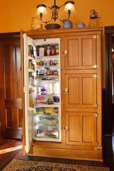 an open refrigerator in a room with wood paneling and light fixtures on the ceiling