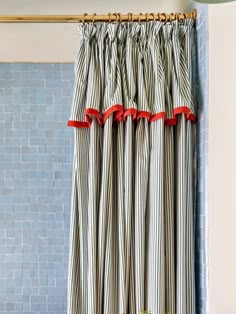 a striped shower curtain with red ribbon on it