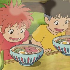 two young children eating food from bowls on a table with chopsticks in front of them