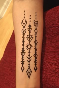 a woman's arm with an arrow and arrows tattoo on the left side of her arm