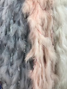 two different colored feathers on display in a store window, one is grey and the other is pink