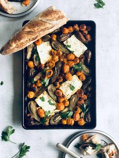 a pan filled with tofu, beans and bread on top of a white table