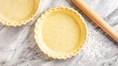 two pie pans sitting on top of a marble counter