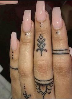 two fingers with different tattoos on them