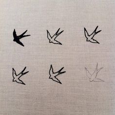 four birds are flying in the sky above each other on a white cloth with black ink