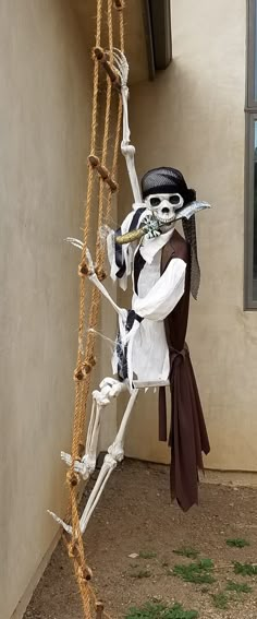 a skeleton dressed up as a pirate climbing a ladder