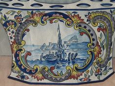 an ornate blue and white vase with boats in the water on it's sides