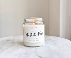 an apple pie candle sitting on top of a marble table next to a white wall