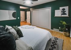 a bedroom with green walls and wooden floors