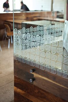 a glass window with some writing on it in a room filled with tables and chairs