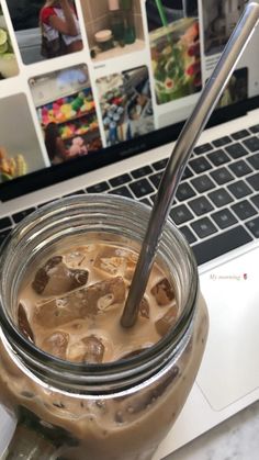 a jar filled with liquid next to a laptop