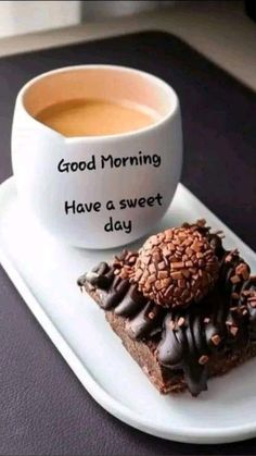 a cup of coffee and two pieces of chocolate cake on a plate with the words good morning have a sweet day