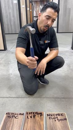 a man kneeling on the floor holding a wrench in front of three pieces of wood