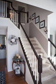 the stairs in this house are decorated with pictures and wreaths on each handrail