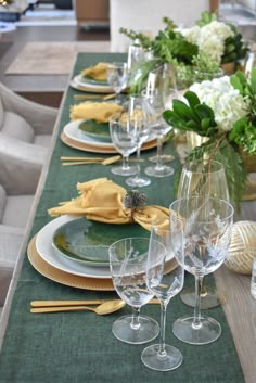 the table is set with wine glasses and place settings