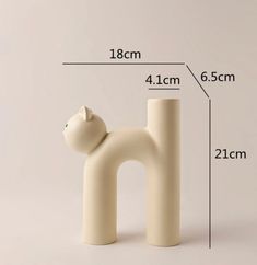 a white cat figurine is shown with measurements