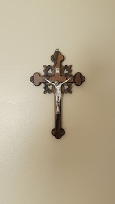 a wooden cross mounted to the wall with a jesus crucifix on it