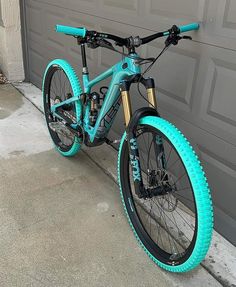 a blue bicycle parked in front of a garage door