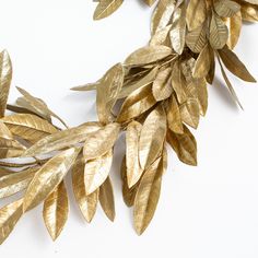 some gold leaves on a white surface