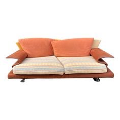 an orange and white couch with two pillows on it's back end, against a white background