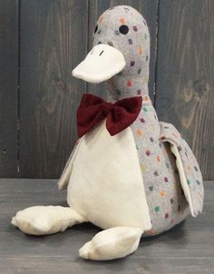 a stuffed penguin with a bow tie sitting on the ground