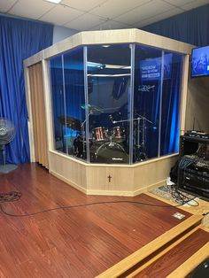 a recording studio with blue curtains and wooden floors