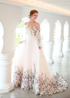 a woman in a white and pink dress posing for the camera