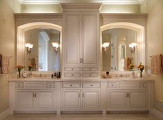 a large bathroom with double sinks and two mirrors on the wall, along with multiple cabinets