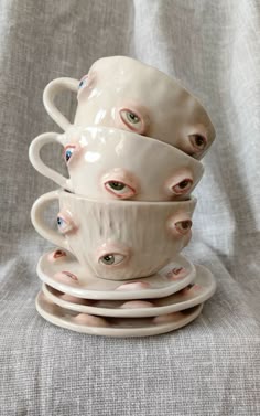 three cups stacked on top of each other with eyes painted on the inside and outside