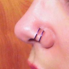 a close up of a person's nose with a ring on the end of their nose