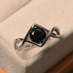 a black diamond ring sitting on top of a white box