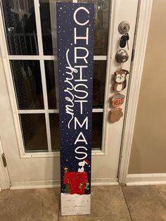 a wooden sign that says christmas in front of a door