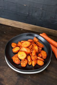 some carrots are sitting on a black plate