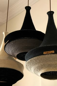 three black and white lamps hanging from the ceiling