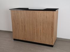 a wooden counter sitting on top of a hard wood floor next to a white wall