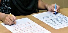 a person sitting at a table with two papers and a pen in front of them