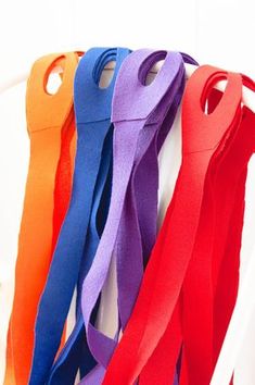 there are many different colored ribbons hanging on the wall with each one's own hook