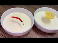 two bowls filled with yogurt and a slice of lemon