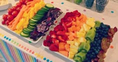 a table filled with lots of different types of fruits and vegetables on it's trays