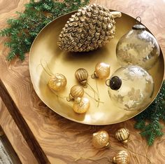 christmas ornaments are arranged on a gold plate