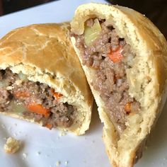 a meat filled pastry cut in half on a plate