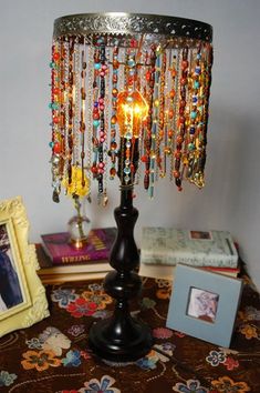 a lamp that is on top of a table with beads and other items around it