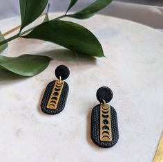 These earrings are classic with a modern twist, featuring a textured black curved-rectangle and a gold brass Moon phase charm. Perfect for fall and an omen of Halloween to come! Moon Phase Clay Earrings, Earrings Moon, Black Curves, Earrings Halloween, Halloween Earrings, Earrings Cute, Gold Brass, Jewelry Business, Moon Phases