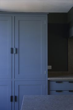 an empty kitchen with blue cabinets and granite counter tops