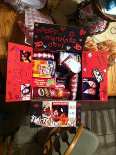 an assortment of valentine's day items is displayed in a box on a chair