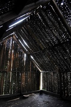 the inside of a building that has lights on and rain drops falling from the roof