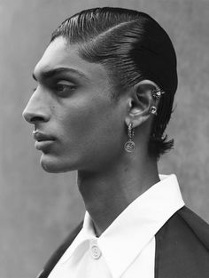 a man with black hair and earrings on his head