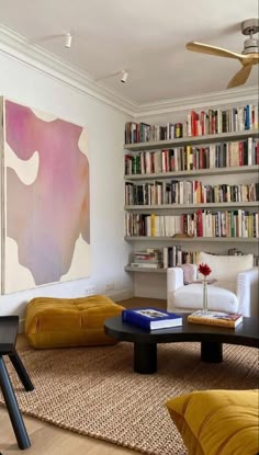 a living room filled with lots of furniture and bookshelves