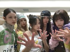 group of young women posing for the camera with their hands in the air and wearing headbands