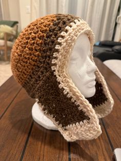 a crocheted hat sitting on top of a white mannequin head